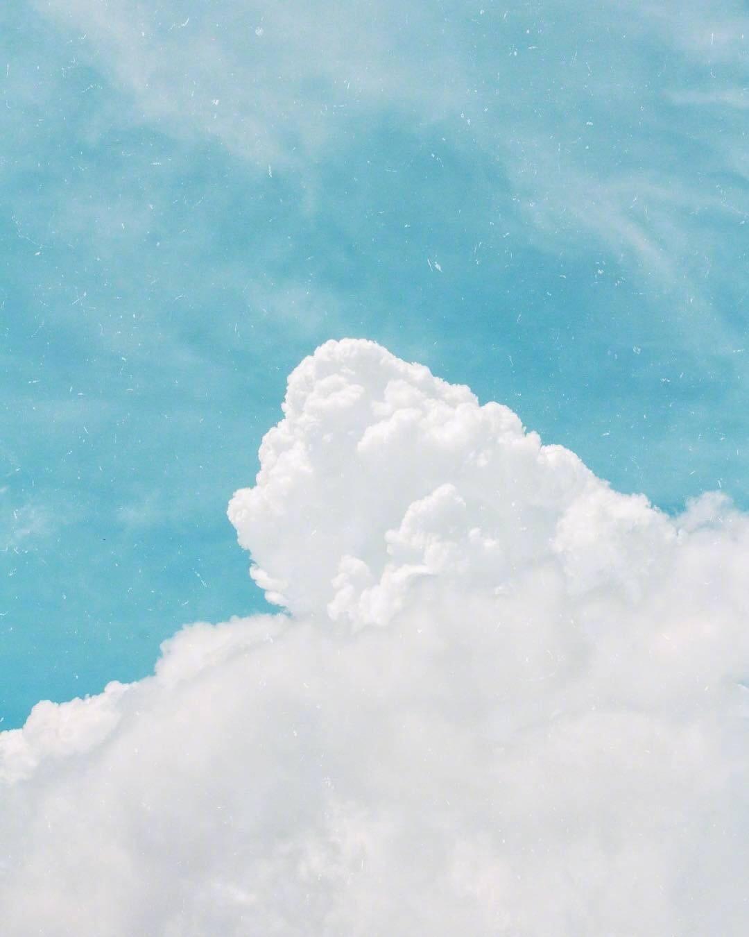 晴朗湛蓝的天空下一朵巨大的白云在阳光下细腻柔软自然风景素材设计